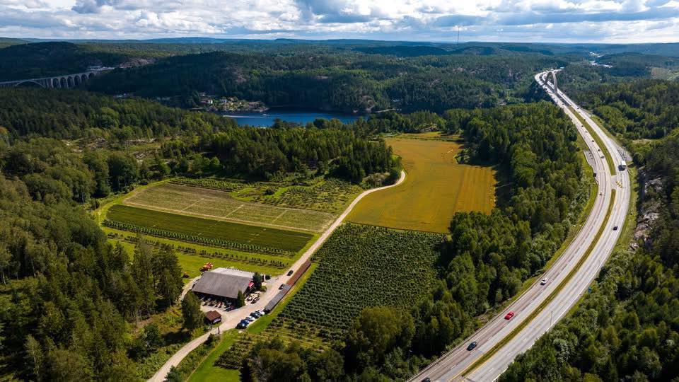 Flyfoto av Svinesundhagen med åkrene, butikken og Svinesundsbrua i bakgrunnen